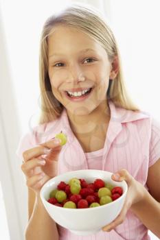Royalty Free Photo of a Girl Eating Fruit