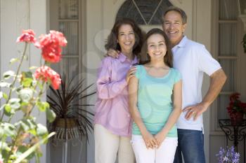 Royalty Free Photo of a Couple Outside Their Home With Their Daughter