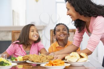 Royalty Free Photo of a Mother Serving a Meal to Her Children