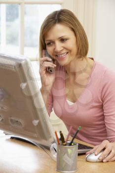 Royalty Free Photo of a Woman at the Computer on the Phone