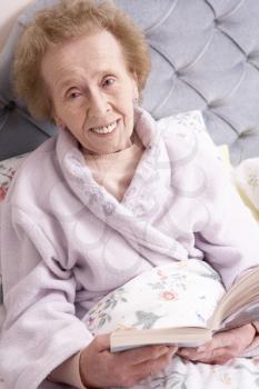 Royalty Free Photo of a Woman Relaxing in Bed With a Book