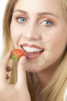 Royalty Free Photo of a Girl Eating a Strawberry