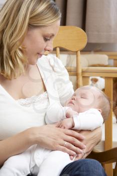 Royalty Free Photo of a Mother Holding a Baby in the Nursery