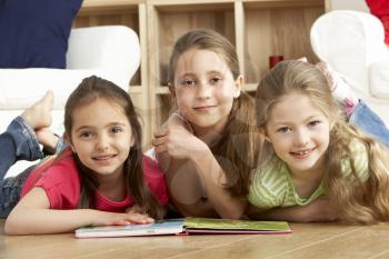 Royalty Free Photo of Three Girls Reading a Book