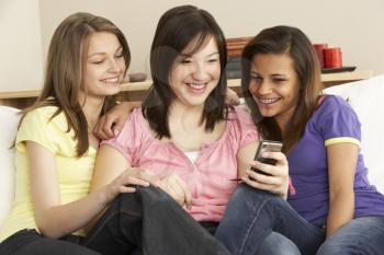 Royalty Free Photo of Girls on a Couch With a Cellphone