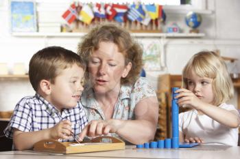 Royalty Free Photo of Two Children With an Adult at Preschool