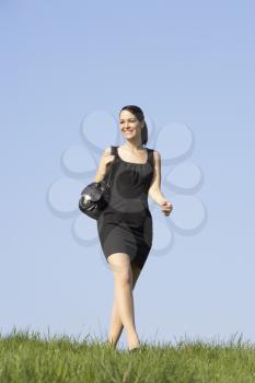Royalty Free Photo of a Woman in Business Attire Walking on Grass