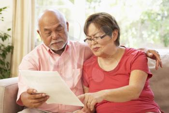 Royalty Free Photo of a Couple Reading a Paper