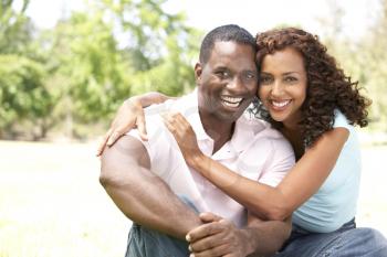 Portrait Of Young Couple Sitting In Park