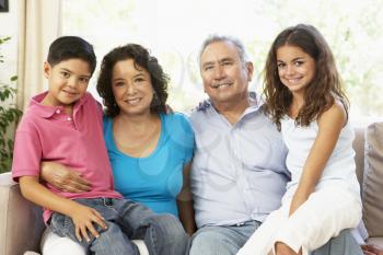 Grandmother Reading With Grandchildren At Home Together