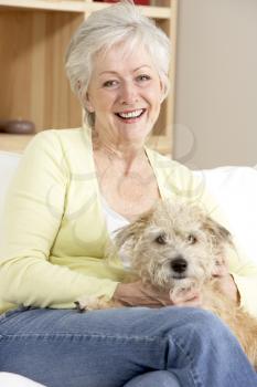 Senior Woman Holding Dog On Sofa