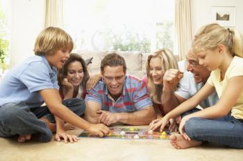 Family Playing Board Game At Home With Grandparents Watching