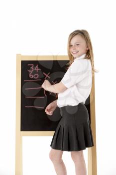 Thoughtful Female Student Wearing Uniform Next To Blackboard