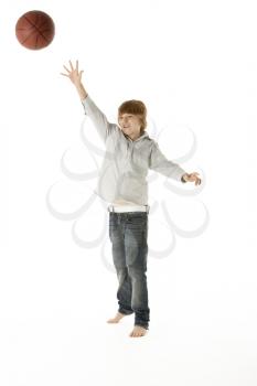 Young Boy Jumping With Basketball In Studio