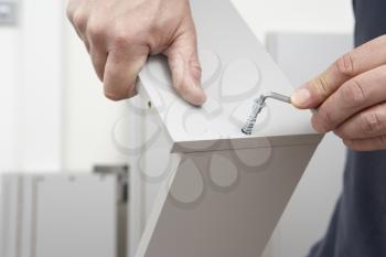 Close Up Of Man Assembling Flat Pack Furniture