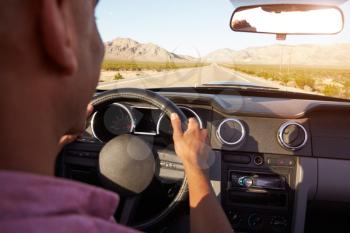 Man In Convertible Car Driving Along Open Road