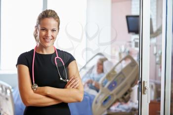 Portrait Of Female Doctor With Patient In Background