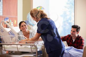 Family And Nurse With New Born Baby In Post Natal Department