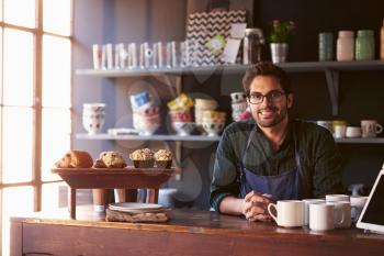 Portrait Of Male Coffee Shop Owner Standing Behind Counter
