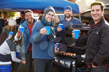 Group Of Male Sports Fans Tailgating In Stadium Car Park