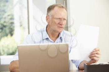 Middle Aged Man Using Laptop At Home