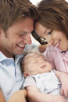 Close Up Of Parents Cuddling Newborn Baby Boy At Home