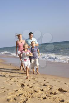 Portrait Of Running Family On Beach Holiday
