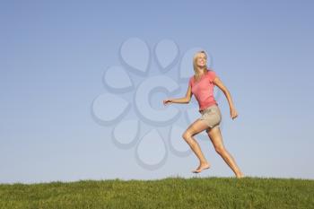 Young woman running through field