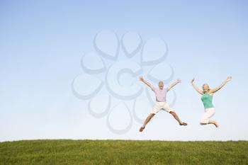 Senior couple jumping in air