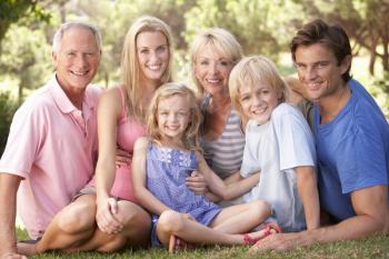 A family, with parents, children and grandparents, relaxing in a park