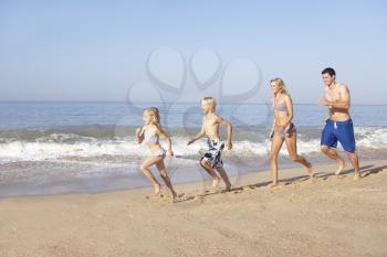 Young family running on beach