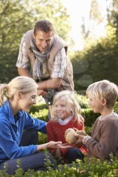 Young family sit together in garden