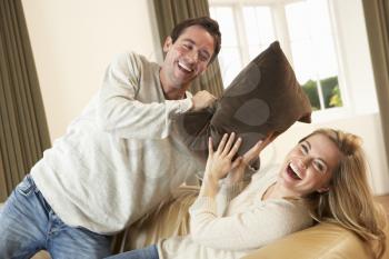 Young couple having fun laughing on sofa