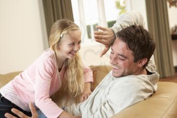Young father with girl having fun on sofa