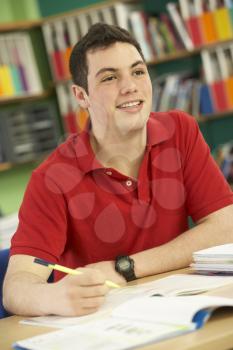 Teenage Male Student In Working In Classroom