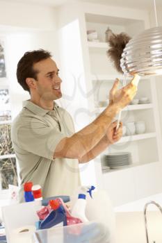 Man Cleaning Light Fitting With Feather Duster