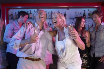 Senior Couple Having Fun In Busy Bar