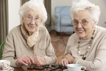 Two Senior Women Playing Dominoes At Day Care Centre