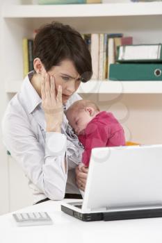 Stressed Woman With Newborn Baby Working From Home Using Laptop