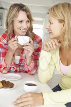 Mid age women chatting over coffee at home