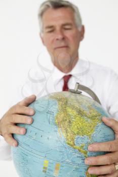 Senior businessman holding globe