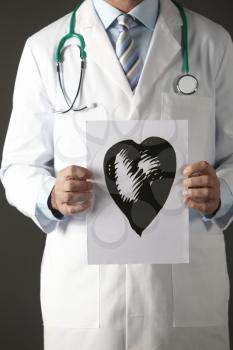 American doctor holding ink drawing of heart