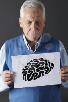 Senior man holding ink drawing of brain