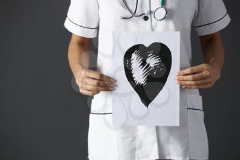 American nurse holding ink drawing of heart