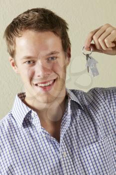 Studio Shot Of Young Man Holding Keys To First Home