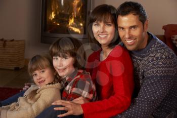 Portrait Of Family Relaxing On Sofa By Cosy Log Fire