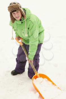 Teenage Boy Shovelling Snow From Path