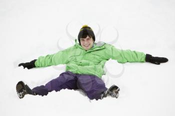 Teenage Boy Making Snow Angel On Slope