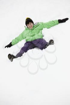 Teenage Boy Making Snow Angel On Slope