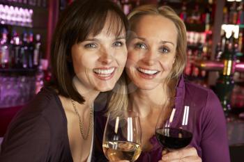 Two Women Enjoying Drink Together In Bar